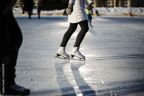 Closeup of young girl on the  figure skates outdoor in sunny spring day