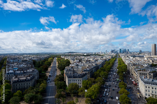 Paris, Blick vom Arc de Triomphe auf Stadt und Häuser unter blauem Himmel mit weißen Wolken an Sommertag © JM Soedher