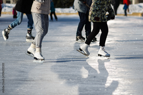 Closeup of group people on the fugure skates outdoor in sunny spring day