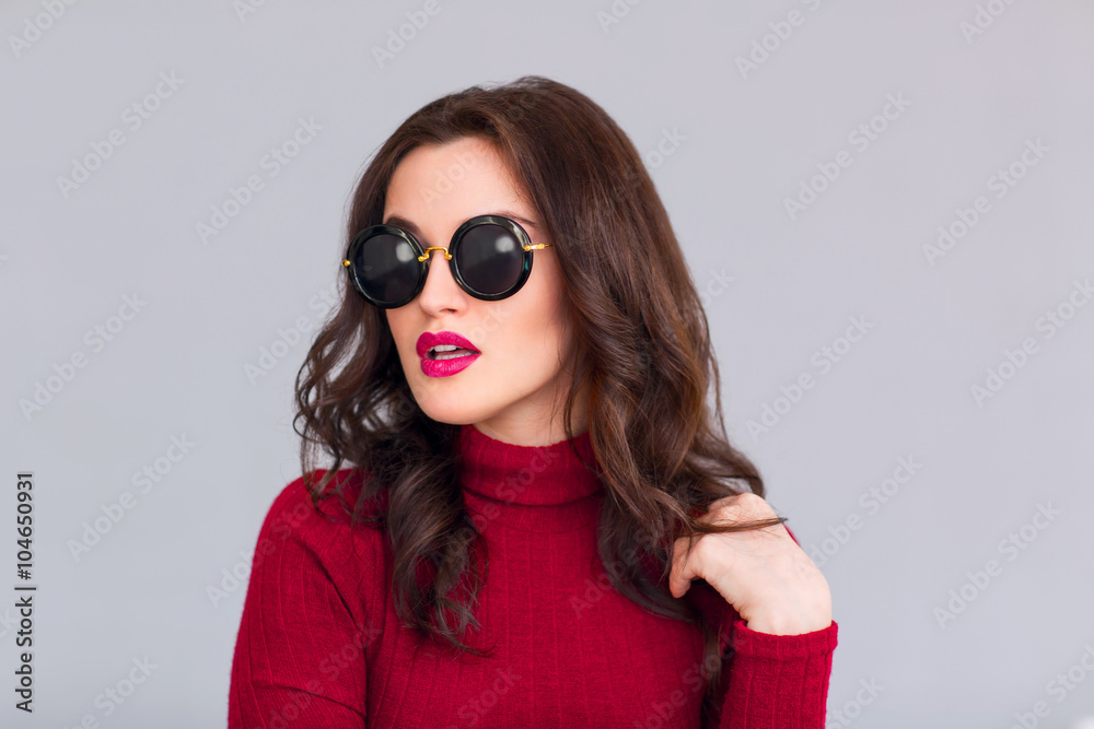 Attractive woman in glasses standing on grey background Attractive woman in glasses standing on grey background