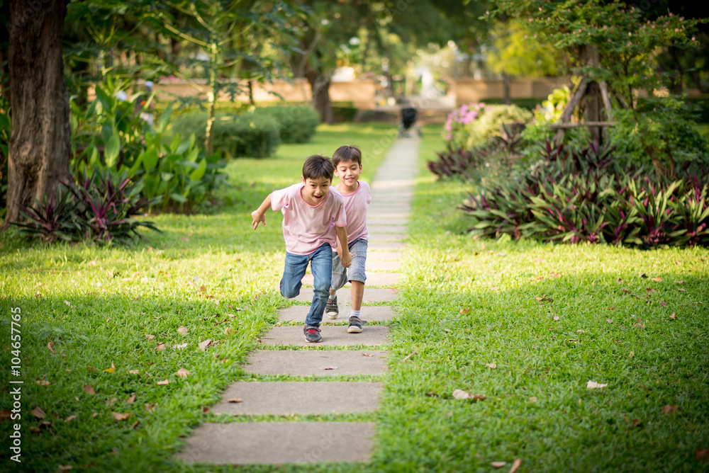 Fototapeta premium Little sibling boy playing together in the park