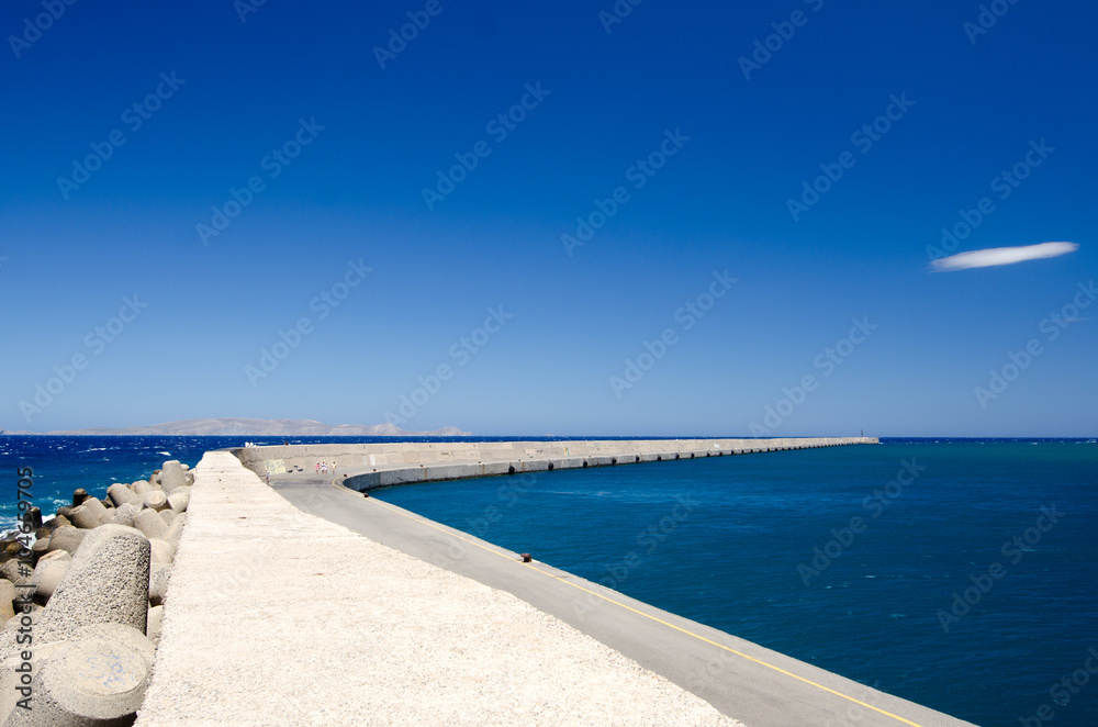Long sea pier in Greece with blue sky
