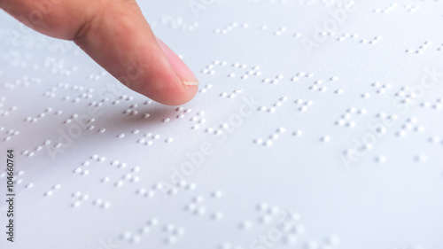 Finger read braille text in white paper. photo