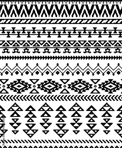 Seamless hand drawn stripes pattern with ethnic and tribal ornament. Vector black and white fashion illustration.