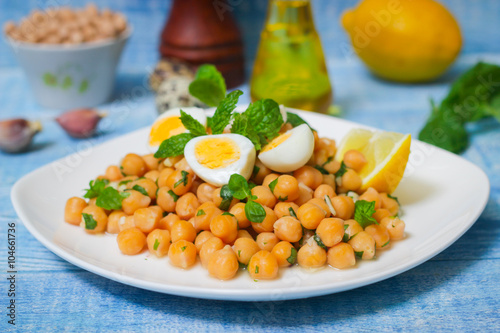 Mediterranean cuisine. Dish of chickpeas with mint, olive oil and lemon sauce on a wooden background