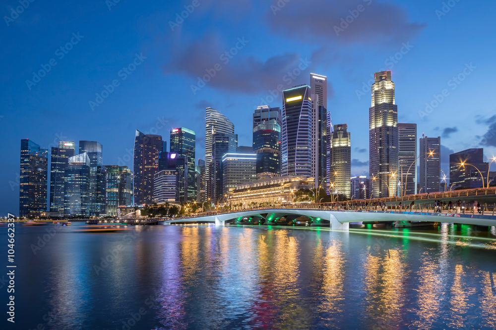 Obraz premium Kolorowe panoramę dzielnicy biznesowej Singapuru po zachodzie słońca w Marina Bay.