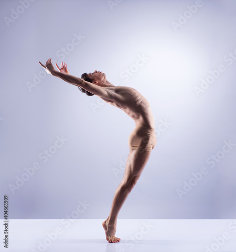 Fototapeta Naklejka Na Ścianę i Meble -  Athletic ballet dancer performing in a studio