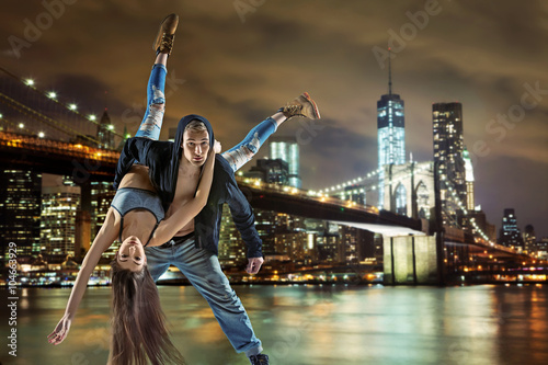 Young hip hop couple dancing, over urban background