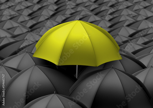 Yellow umbrella above black umbrellas