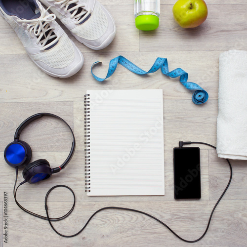 Notebook, smartphone with music, sport equipment and healthy food