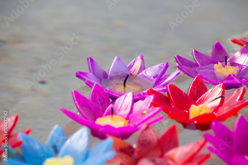 violet artificial flower candle floating on water photo