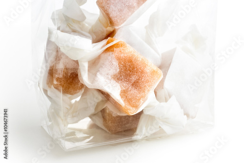 Detail of cellophane packet of wrapped caramel toffees.