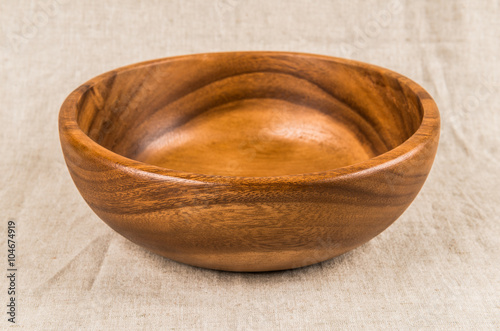 Wooden bowl on linen tablecloth.