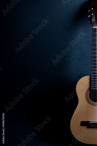 Half of an old acoustic guitar on a black background (with copy space)