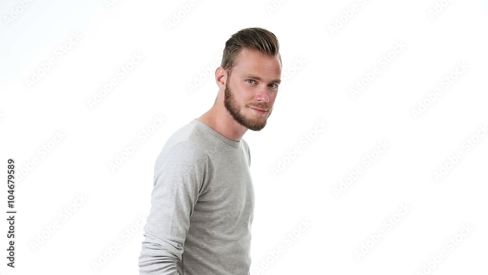 A handsome man wearing a grey shirt and jeans, standing in front of a white background in a studio, feeling calm and relaxed. A handsome man wearing a grey shirt and jeans, standing in front of a white background in a studio, feeling calm and relaxed.