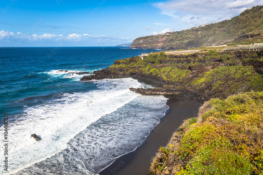 Beach el Bollullo black brown sand and aqua water near Puerto de