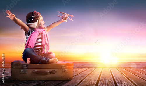 Dream journey - Little Girl On Vintage Suitcase At Sunset 
