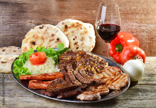 Wholesome platter of mixed meats including grilled steak. Balkan food photo