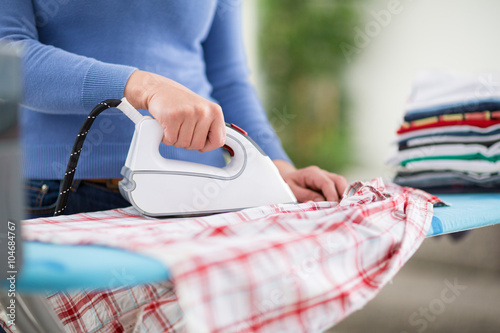 Valokuvatapetti Woman from ironing services iron clothes.
