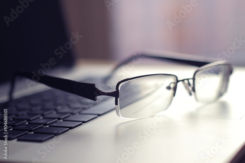 computer keyboard and glasses on a modern workplace businessman