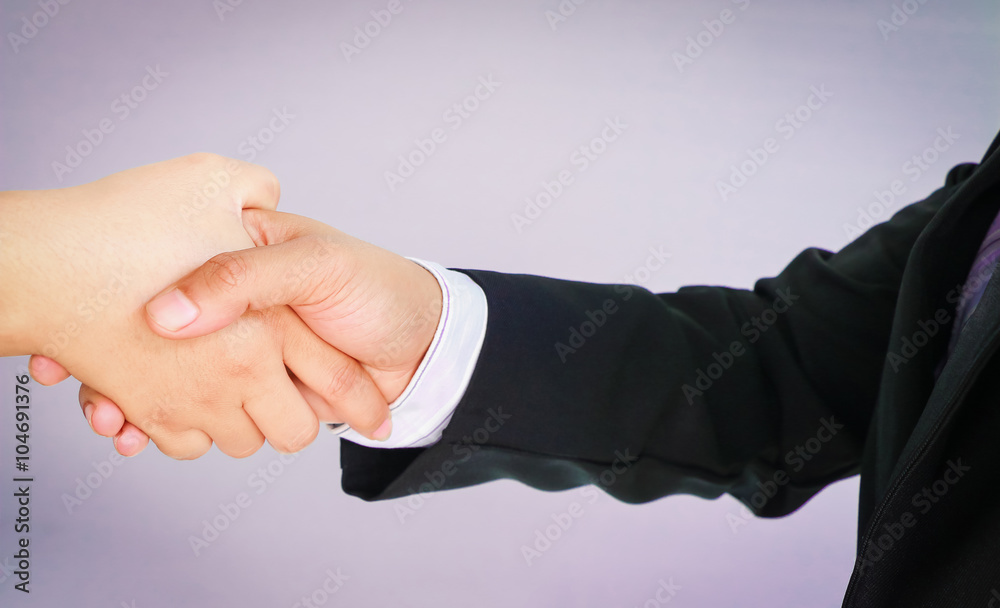 Businessman's handshake on gray background vintage tone.