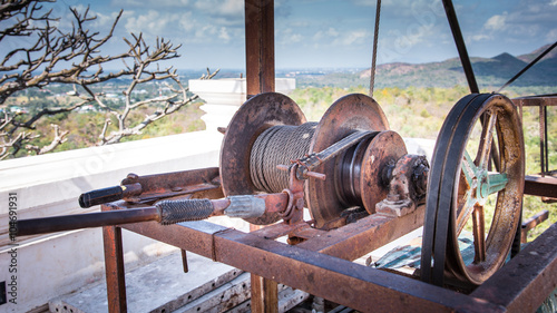 An old machine including reel , belt and basket. Aged by time and cover with rust. The machine is in near wreckage state and almost broken. photo