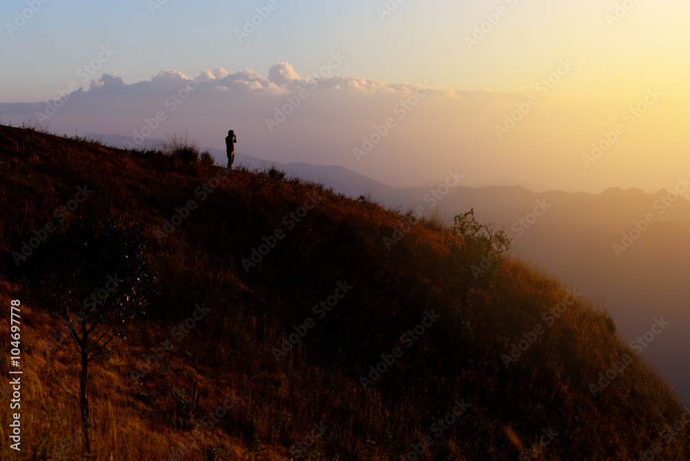 Silhouette man hiker take a photo of mountain view.