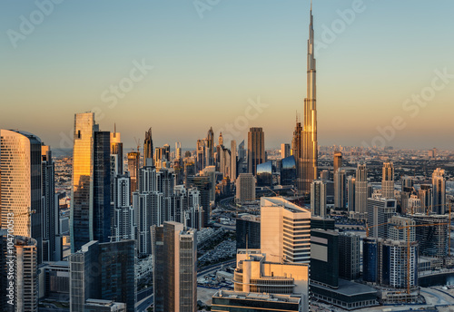 Obraz na płótnie Beautiful modern city architecure at golden sunset. View of Dubai's business bay towers. w salonie