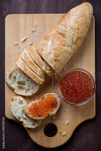 Above view of salmon red caviar and french baguette, studio shot