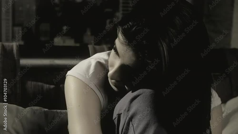Sad lonely girl sitting on bed feeling heart broken slow motion closeup