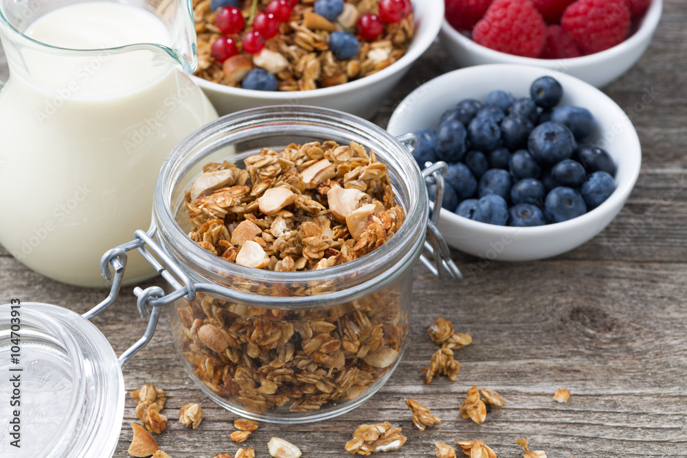 glass jar with granola, milk, and fresh berries glass jar with granola, milk, and fresh berries