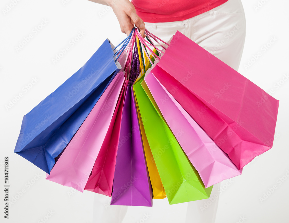 Young woman in white pants with shopping bags