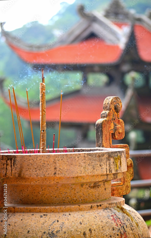 Incense sticks in the temple, Vietnam. Golden casks with incense sticks.