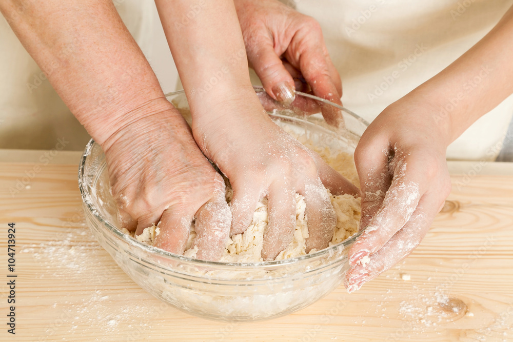 the grandmother and the granddaughter knead dough
