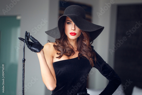 Sexy woman in hat holding whip Stock Photo | Adobe Stock