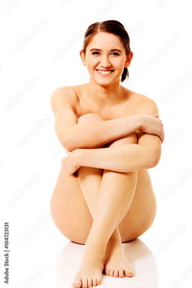 Young naked woman sitting on the floor Young naked woman sitting on the floor