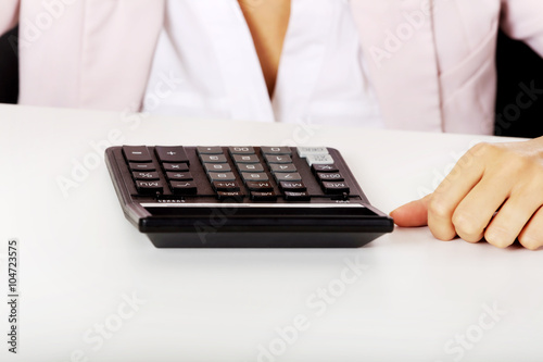 Close-up photo of female sitting behind the desk with calculator
