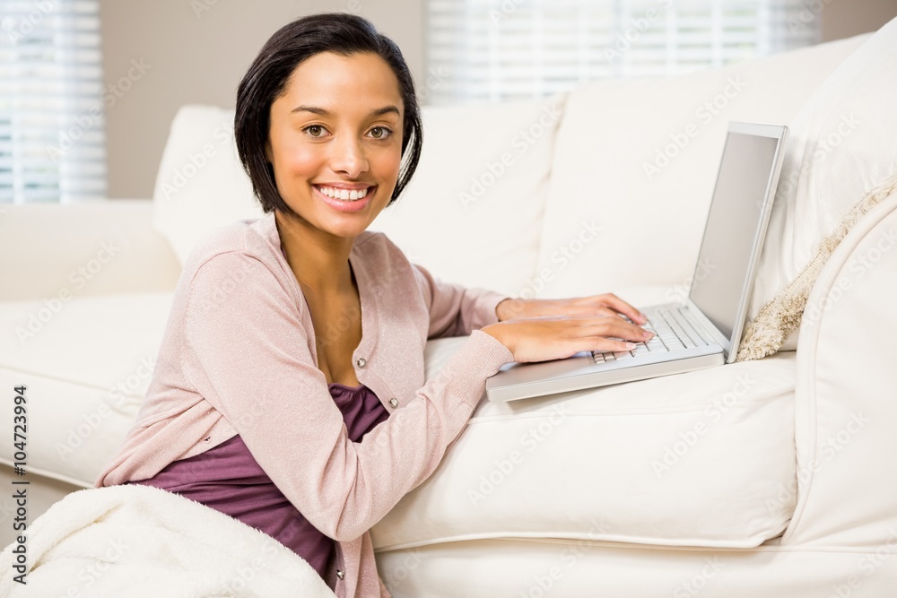 Smiling brunette using laptop Smiling brunette using laptop