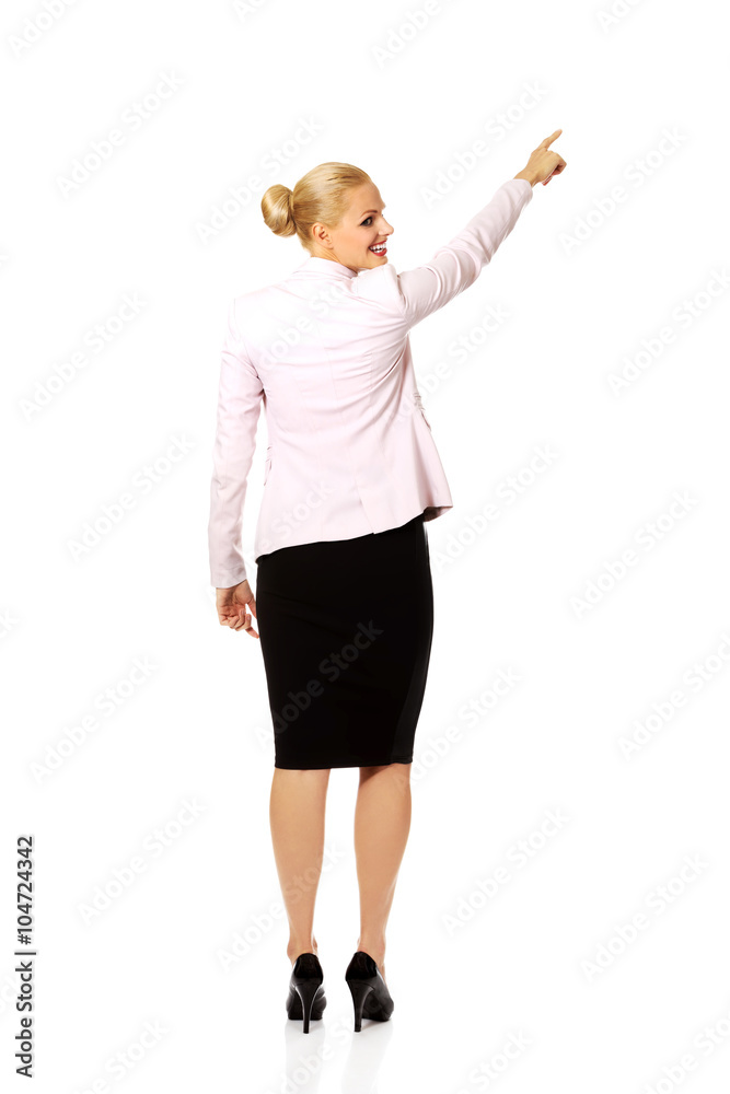 Back view of young business woman pointing for somathing Back view of young business woman pointing for somathing