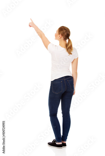 Young woman pointing on copy space or something