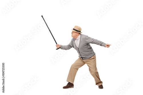 Angry senior holding his cane as a sword
