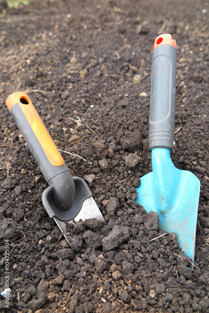 Garden scoops in the loosen soil in the garden Garden scoops in the loosen soil in the garden