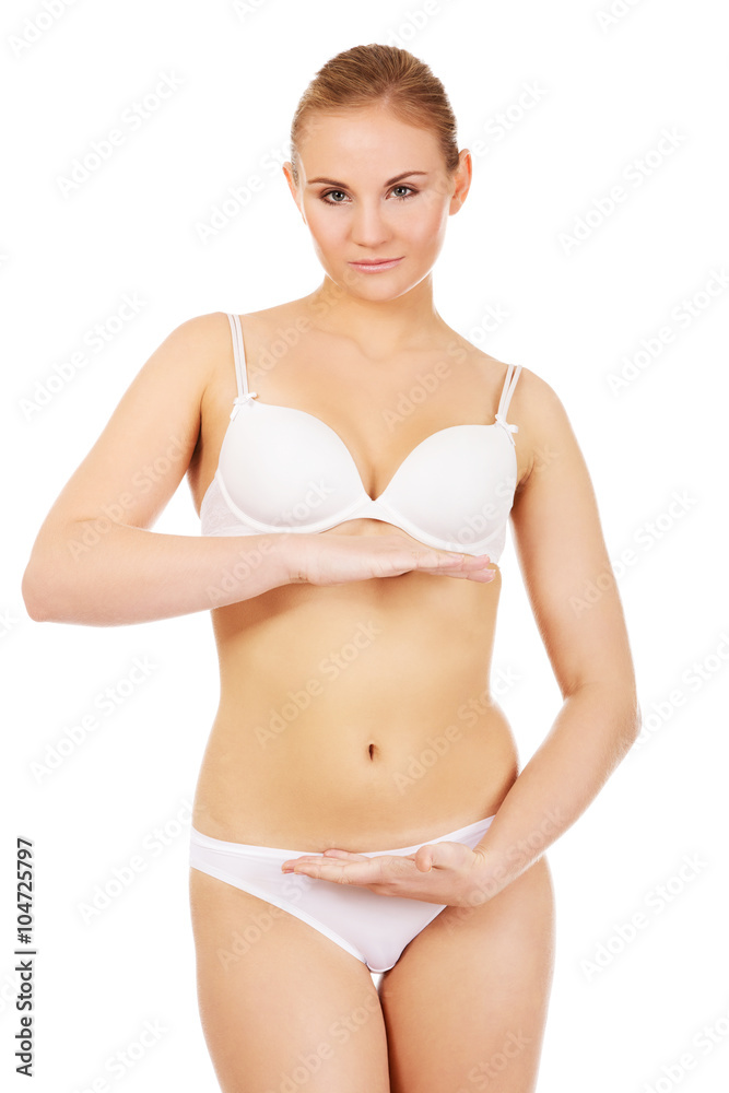 Fototapeta premium Young woman in white lingerie with hand on belly