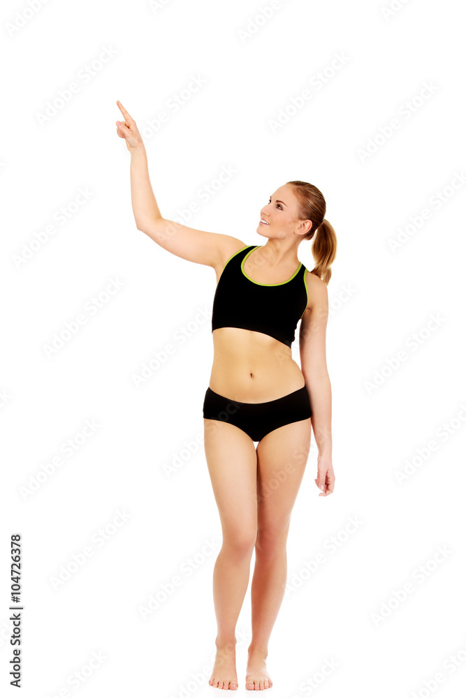 Young athletic woman pointing for copyspace or something Young athletic woman pointing for copyspace or something