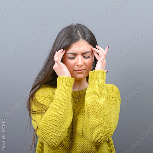 Portrait of woman concentrating against gray background photo