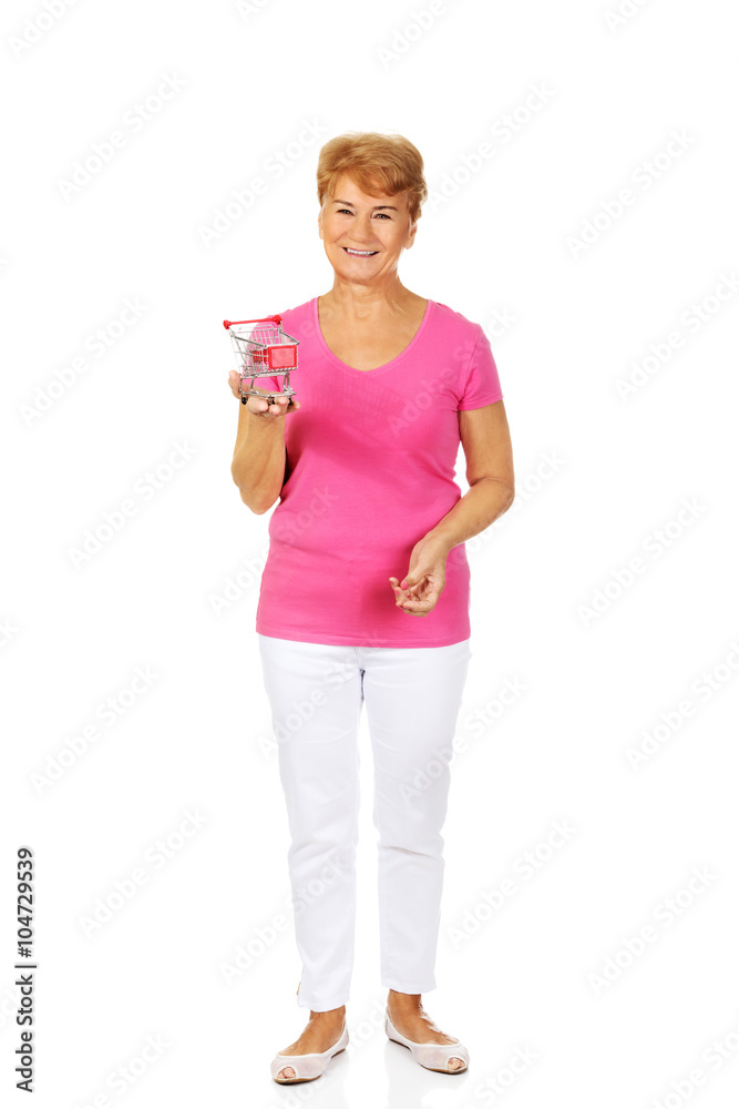 Senior smiling woman holding small trolley Senior smiling woman holding small trolley