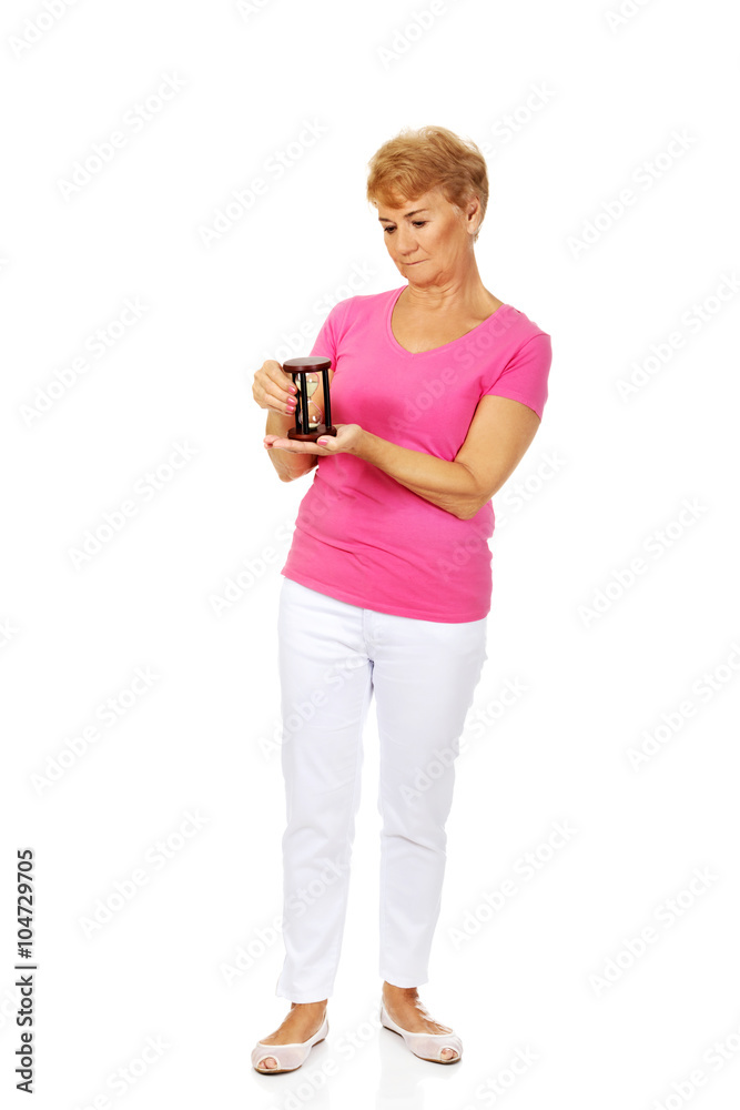 Smile senior woman holding sandglass