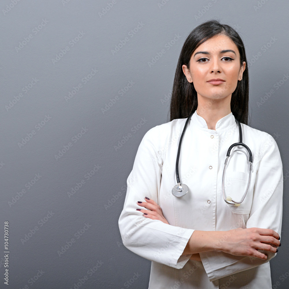 Portrait of young beautiful woman doctor against gray background Portrait of young beautiful woman doctor against gray background