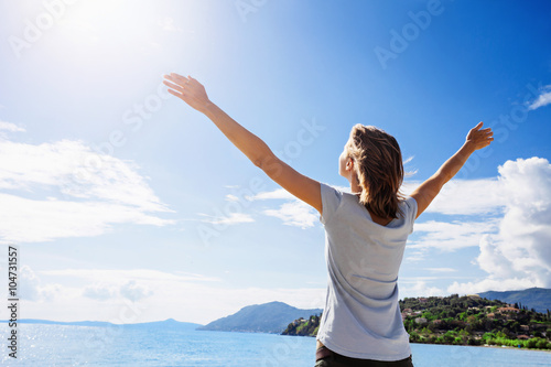 Carefree woman enjoying sun. Vacation and travel concept