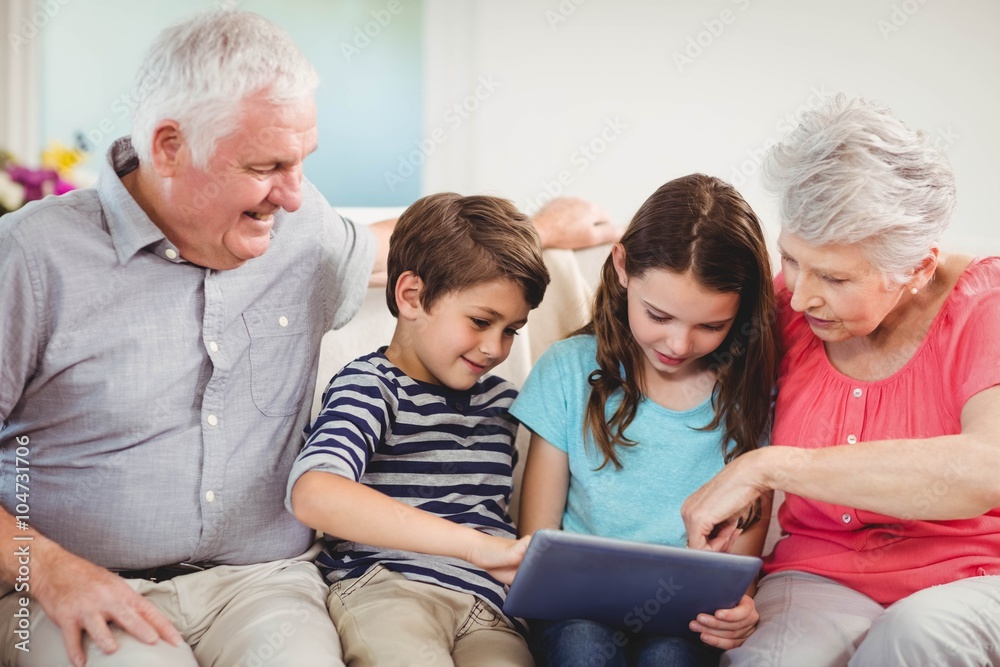 Senior couple using digital tablet with their grand children Senior couple using digital tablet with their grand children